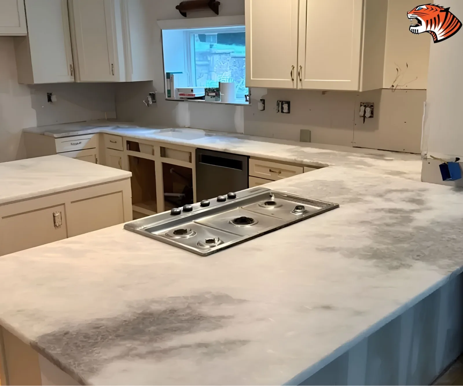 Marble-look quartz kitchen countertops featuring a cooktop cutout during an active remodeling project.