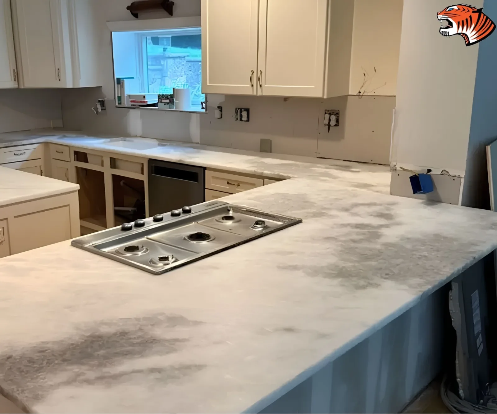 Marble-look quartz kitchen countertops featuring a cooktop cutout during an active remodeling project.