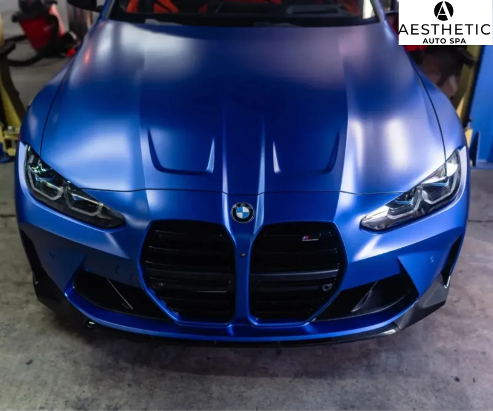 Direct front close-up view of a matte blue BMW M series hood and front grille.