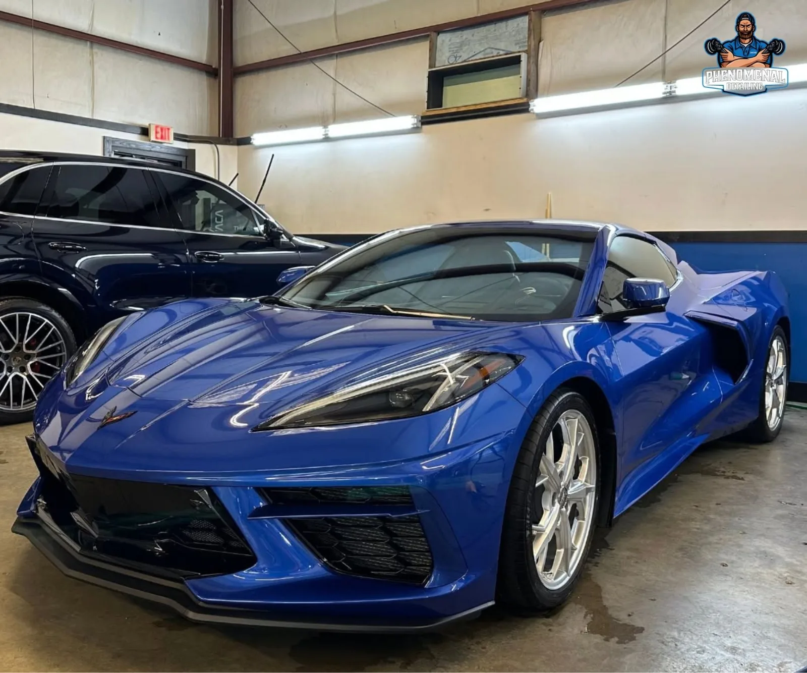 Front three-quarter view of a shiny purple and blue color-shifting Tesla Model S parked indoors.